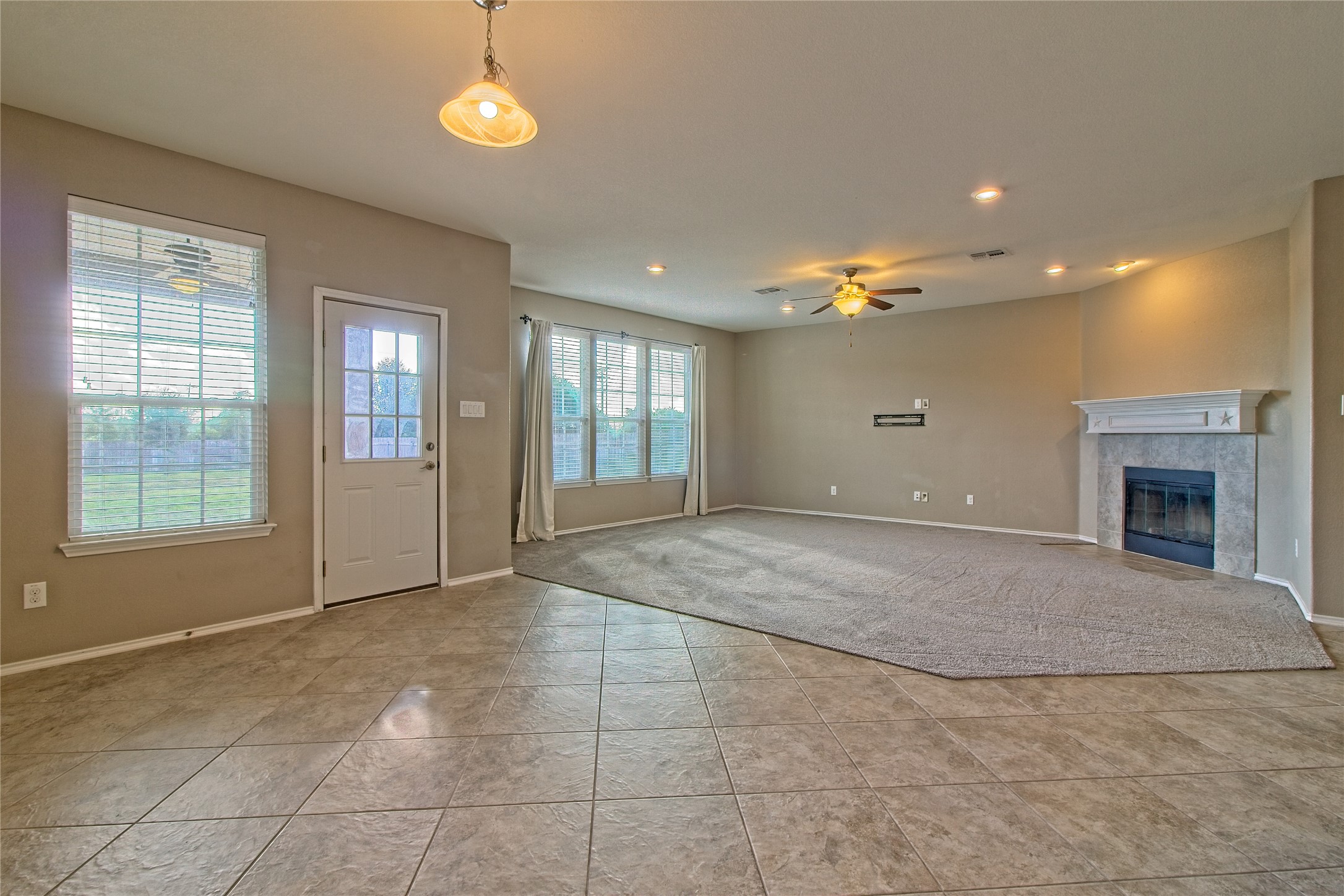 31443 Kingsway Road Georgetown, TX 78628 - Photo 11 of 40 A well-lit living area features a warm fireplace and mixed flooring, offering both comfort and practicality.