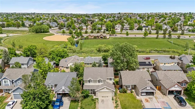 an aerial view of a house with a yard and large trees