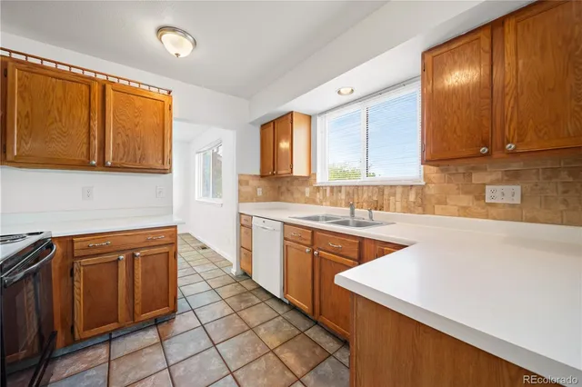 a kitchen with granite countertop a refrigerator stove top oven and sink