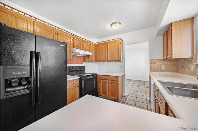 a view of a kitchen with kitchen island wooden floor and a ceiling fan