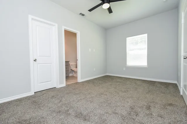 a bathroom with a granite countertop toilet sink and mirror