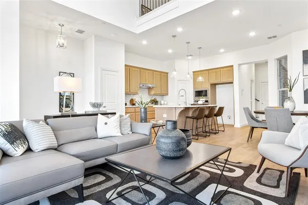 a living room with furniture kitchen view and a large window