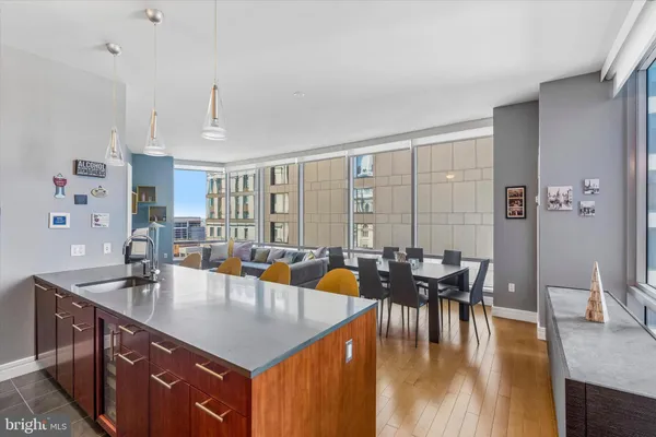 a living room with furniture kitchen view and large windows