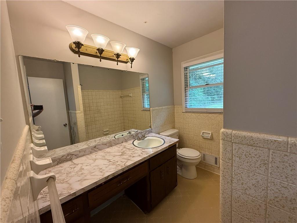 3155 Oak Drive Lawrenceville, GA 30044 - Photo 34 of 46 a bathroom with a granite countertop sink a toilet a mirror and shower