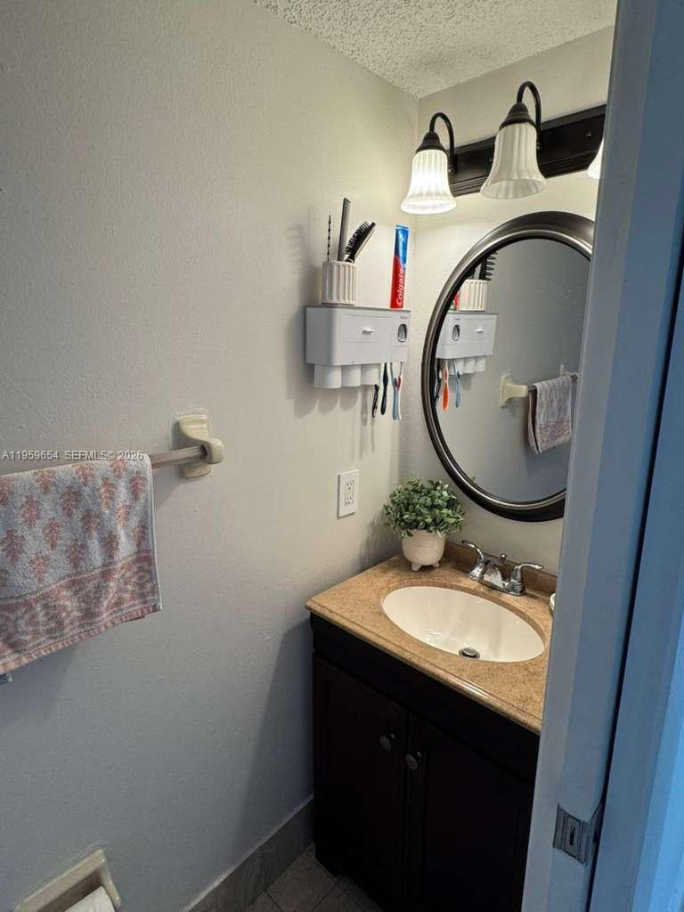 5083 West 12th Lane, Unit D6 Hialeah, FL 33012 - Photo 14 of 16 a bathroom with a sink and a mirror