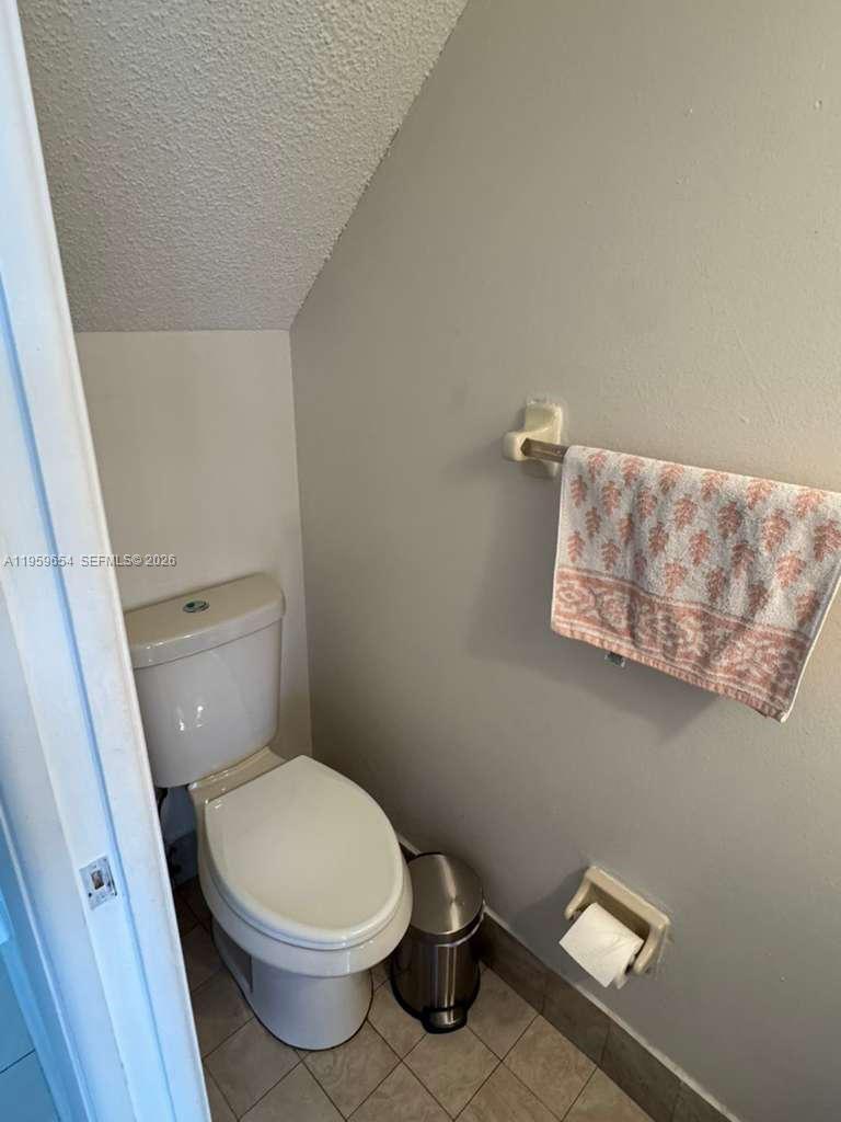 5083 West 12th Lane, Unit D6 Hialeah, FL 33012 - Photo 15 of 16 a white toilet sitting next to a small bathroom