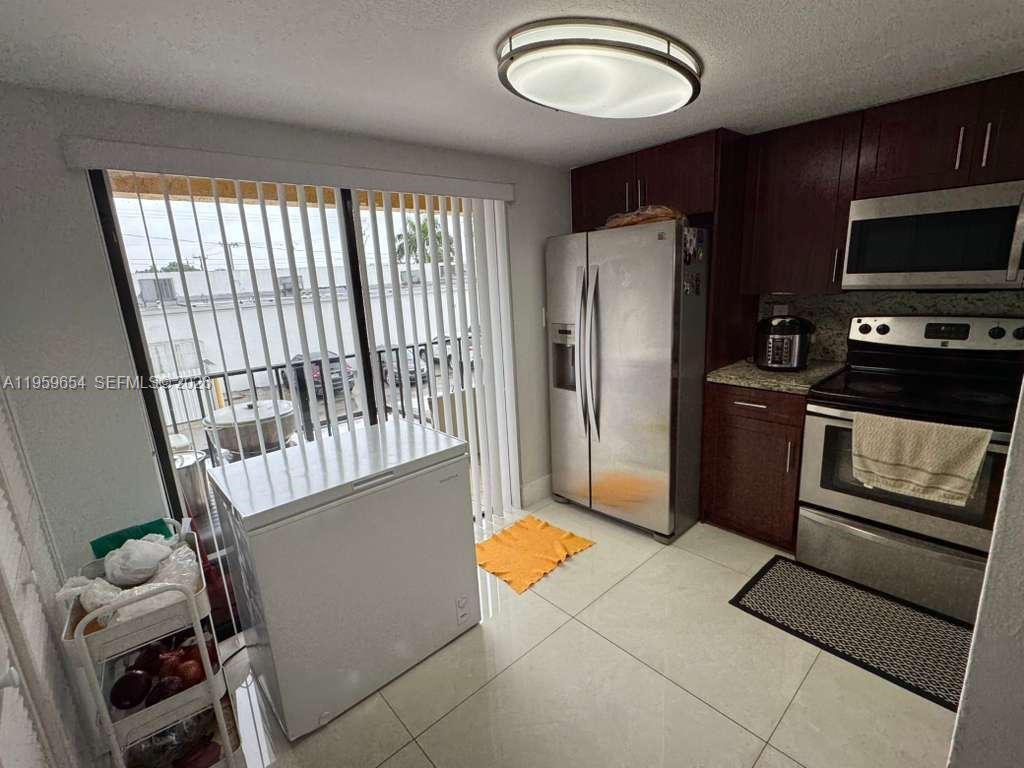 5083 West 12th Lane, Unit D6 Hialeah, FL 33012 - Photo 5 of 16 a kitchen with stainless steel appliances granite countertop a refrigerator and a sink