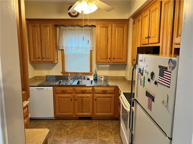 a utility room with stainless steel appliances a sink and a refrigerator