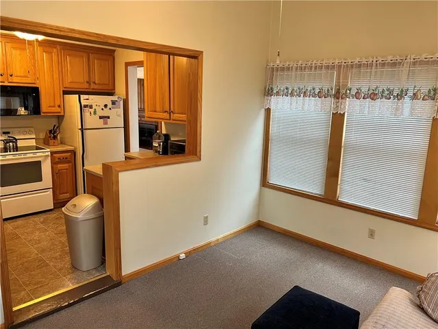 a view of a kitchen with fridge and wooden floor