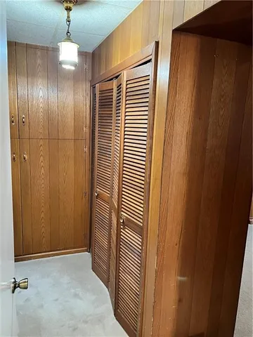 a view of a hallway with wooden shelves