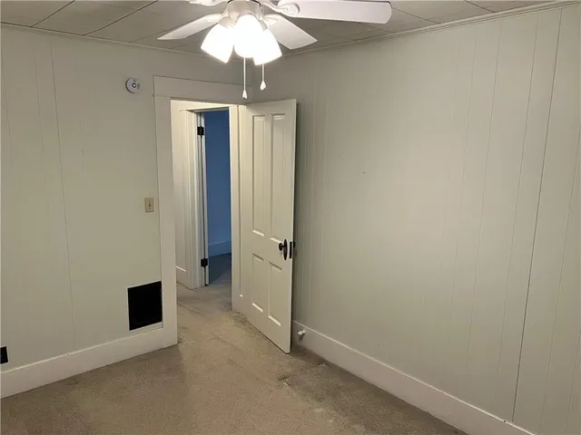 an empty room with a chandelier fan and a chandelier fan
