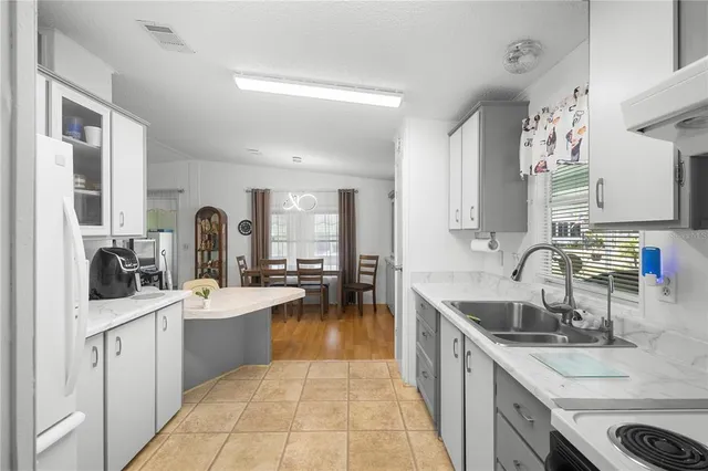 a large kitchen with a sink stove and cabinets