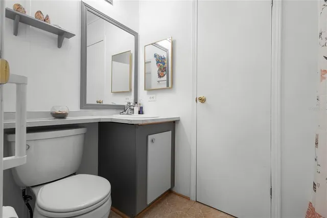 a bathroom with a granite countertop toilet sink and mirror