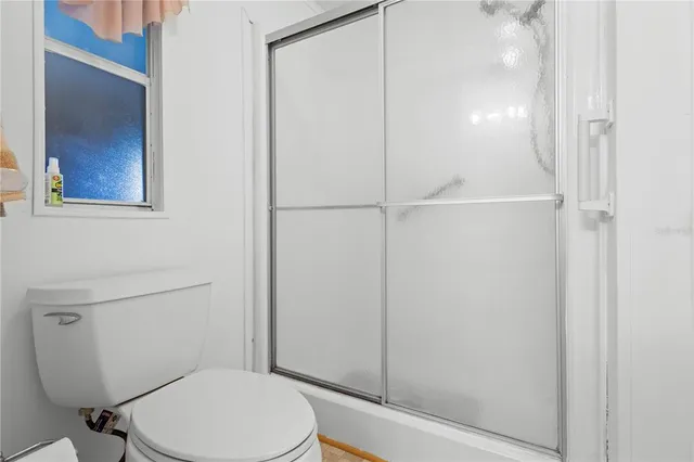 a white toilet sitting next to a shower