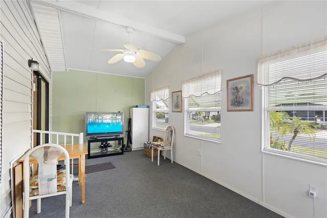 a living room with furniture a flat screen tv and a window