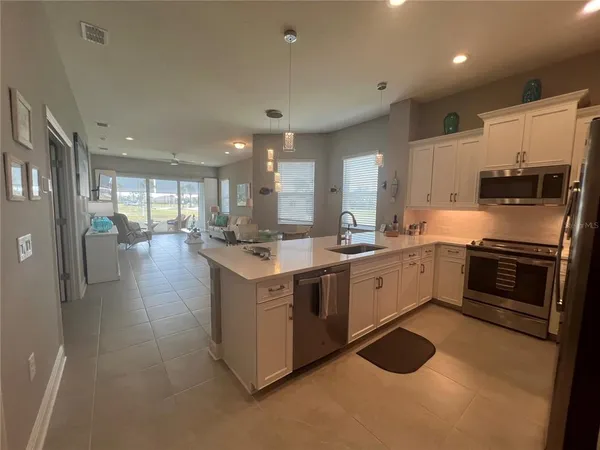 a kitchen with stainless steel appliances granite countertop a stove top oven a sink and a refrigerator