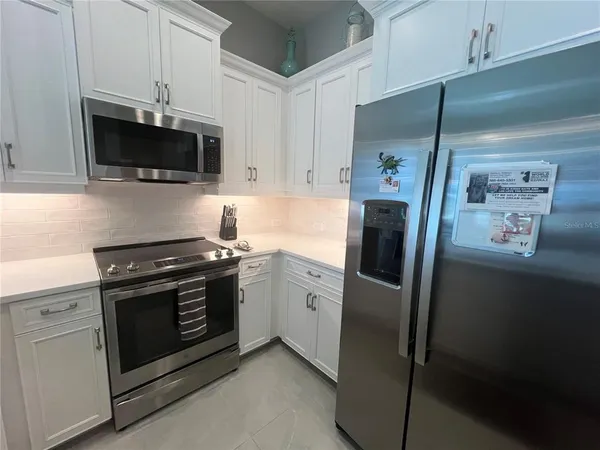 a kitchen with stainless steel appliances a stove a microwave and a refrigerator