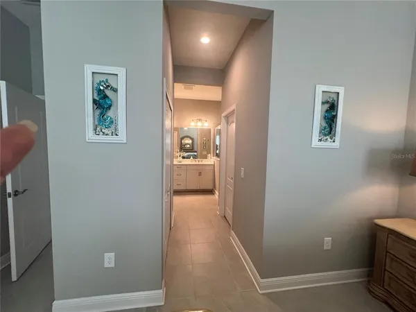 a view of a hallway with wooden floor and a bathroom