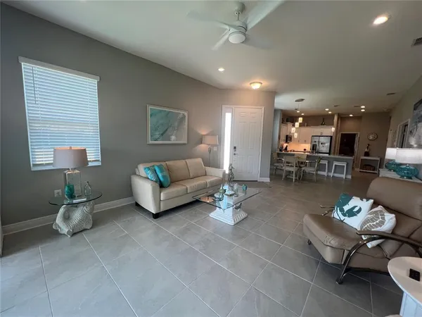 a living room with furniture and a dining table with kitchen view