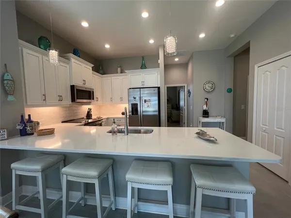 a kitchen with refrigerator a sink and chairs