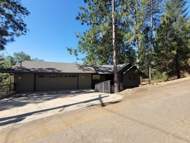 a view of house with tree and a wooden fence