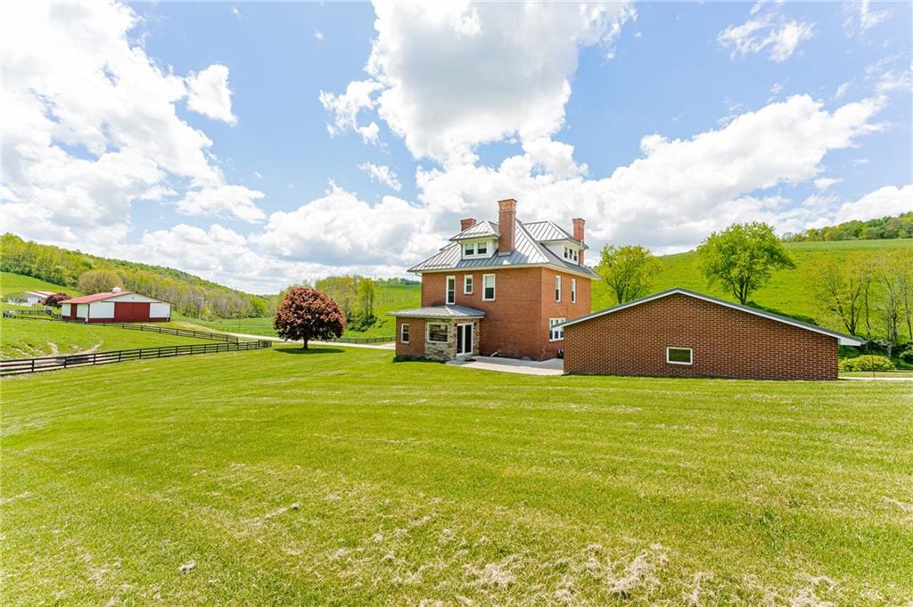 474 Scott Run Road Sycamore, PA 15364 - Photo 7 of 25 a house with a field with trees in the background