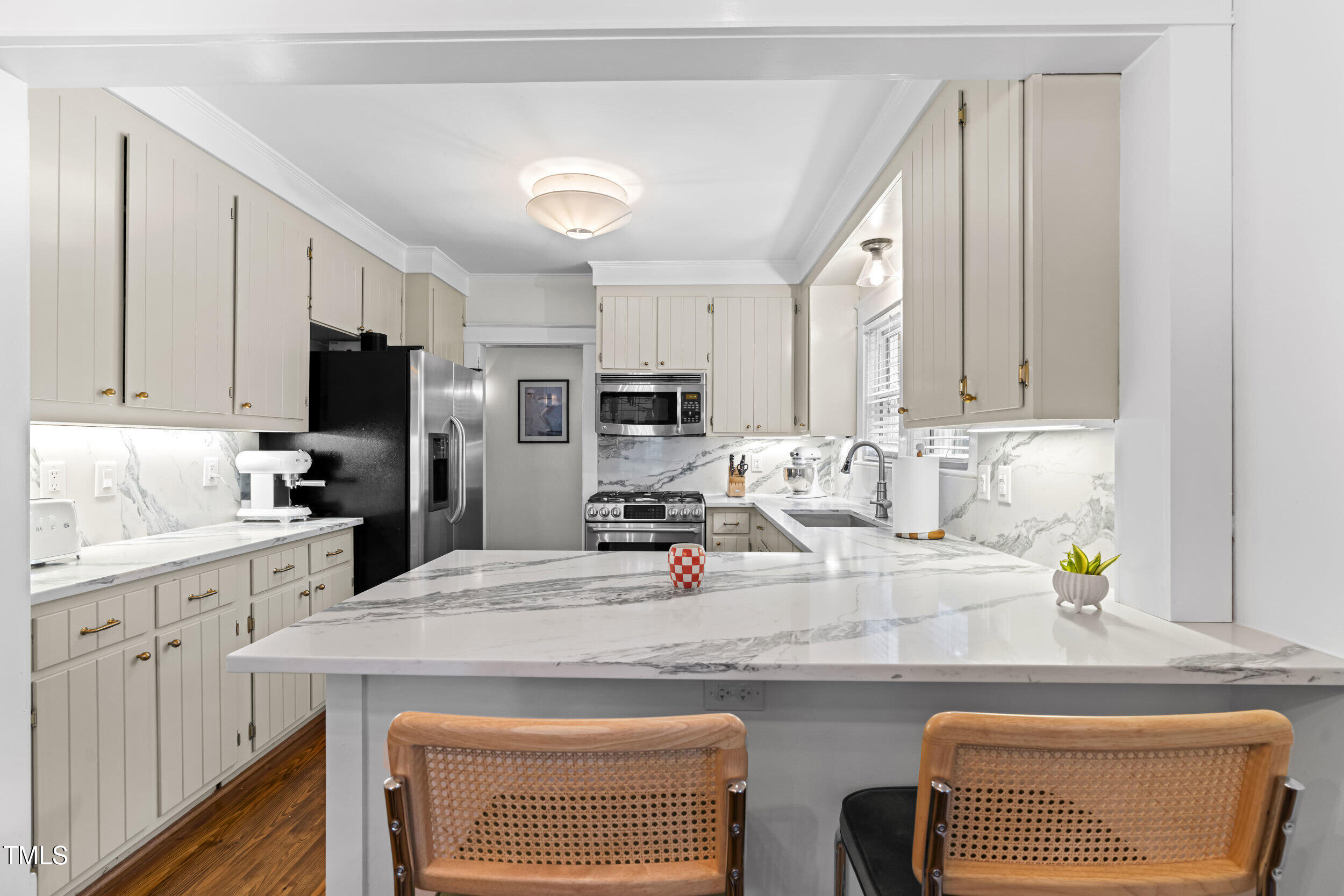 1314 Wake Forest Road Raleigh, NC 27604 - Photo 17 of 32 a kitchen with stainless steel appliances granite countertop a stove top oven a refrigerator a sink and dishwasher with wooden floor