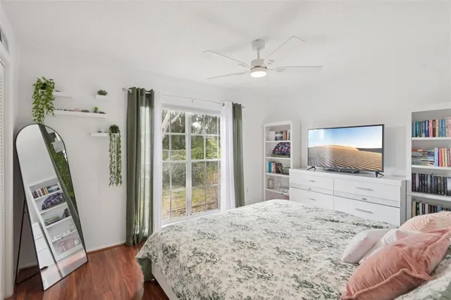 a bedroom with a bed flat screen tv and a bookshelf