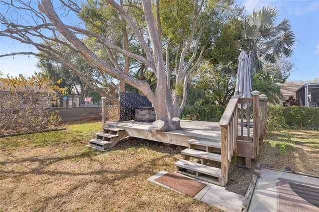 a view of backyard with wooden fence and large trees