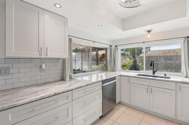a white kitchen with sink and cabinets