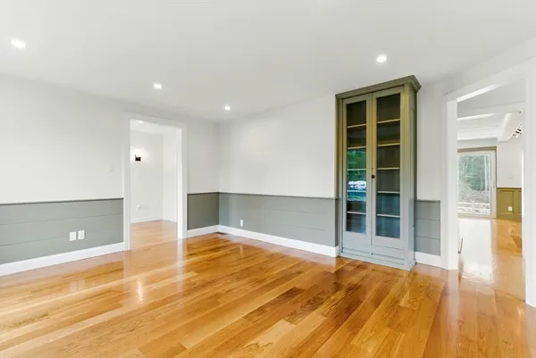 a view of empty room with wooden floor and windows