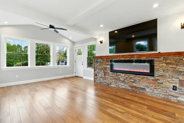 a living room with a large window wooden floor and a rug