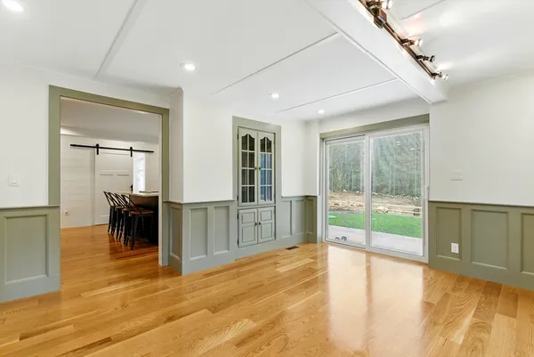 a view of empty room with wooden floor and floor to ceiling window
