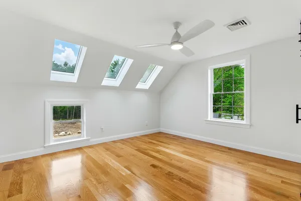 a view of an empty room with a window and a chandelier fan