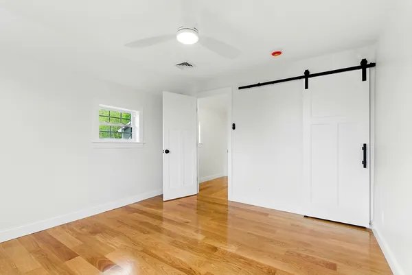 a view of a room with wooden floor and white walls