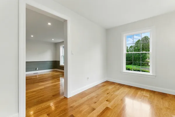 a view of empty room with wooden floor