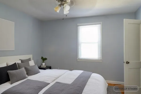 a bedroom with a bed wall painting and a window