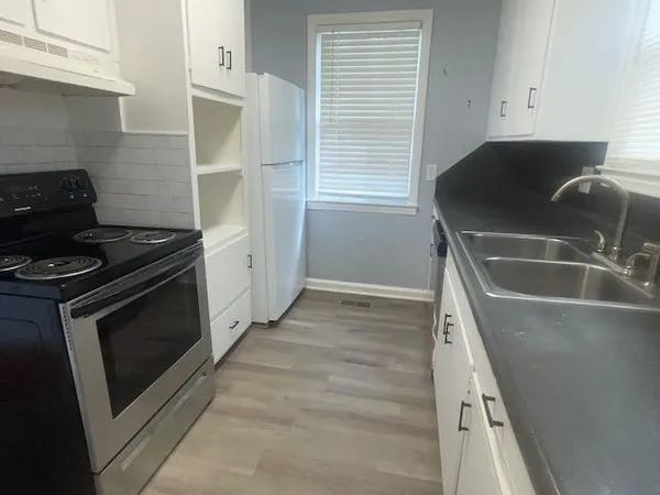 a kitchen with granite countertop a sink and a stove