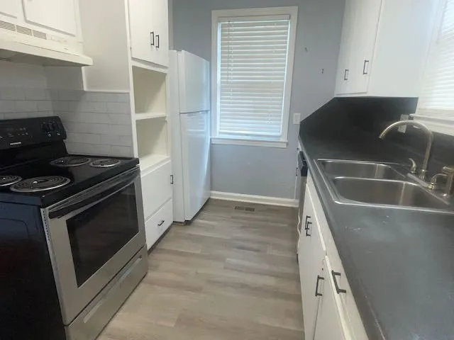 a kitchen with granite countertop a sink and a stove