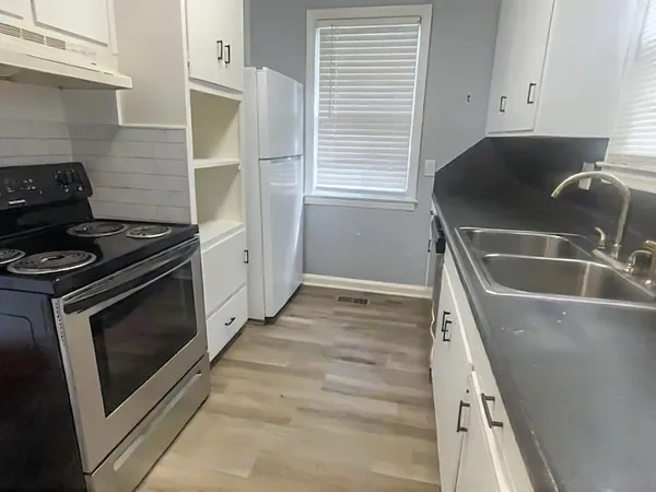 a kitchen with granite countertop a stove and a sink