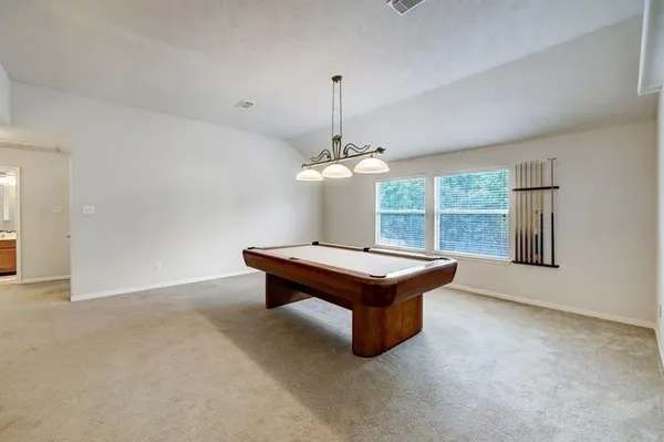 a room with pool table and windows