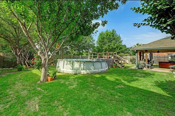 a view of a house with backyard and a tree
