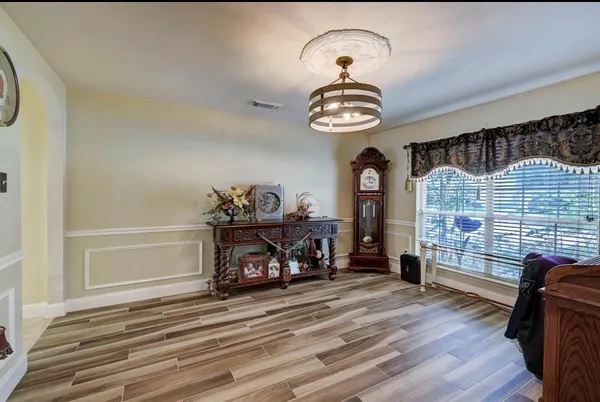 a view of a livingroom with furniture wooden floor and windows