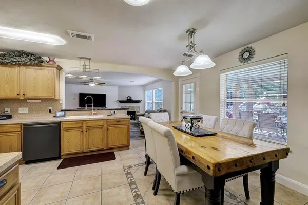 a kitchen with a table chairs sink and cabinets