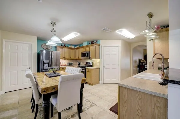 a kitchen with a dining table chairs refrigerator and cabinets