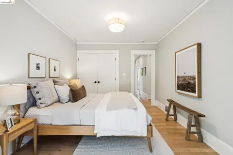 a bedroom with a bed and a lamp on dresser