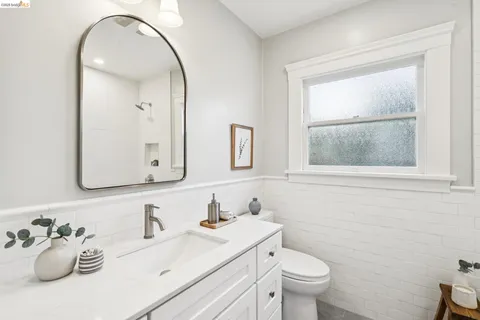 a bathroom with a toilet sink mirror and vanity
