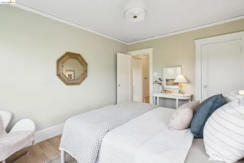 a bedroom with a bed large mirror and wall paintings