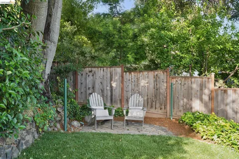 a view of a chair and table in backyard of the house