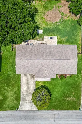 a aerial view of a house with a yard and large trees